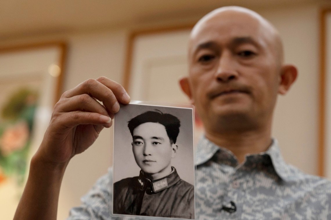 Zhang Hai holds up a photo of his father taken in his youth during an interview in Shenzhen in southern China's Guangdong province on Friday, Oct. 16, 2020. Zhang is demanding to meet a visiting World Health Organization expert team, saying it should speak with affected families who allege they are being muffled by the Chinese government.(AP Photo/Ng Han Guan) Zhang Hai holds up a photo of his father taken in his youth during an interview in Shenzhen in southern China's Guangdong province on Friday, Oct. 16, 2020. Zhang is demanding to meet a visiting World Health Organization expert team, saying it should speak with affected families who allege they are being muffled by the Chinese government.(AP Photo/Ng Han Guan)