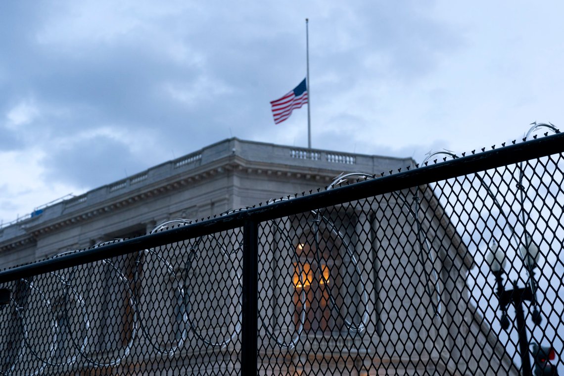 A flag is at half staff in honor of the officer who was killed in the Capitol riot, as a House Office Building is seen through razor wire and and an anti-scaling security fencing, Saturday, Jan. 16, 2021, in Washington, as security is increased ahead of the inauguration of President-elect Joe Biden and Vice President-elect Kamala Harris. (AP Photo/Jacquelyn Martin) A flag is at half staff in honor of the officer who was killed in the Capitol riot, as a House Office Building is seen through razor wire and and an anti-scaling security fencing, Saturday, Jan. 16, 2021, in Washington, as security is increased ahead of the inauguration of President-elect Joe Biden and Vice President-elect Kamala Harris. (AP Photo/Jacquelyn Martin)