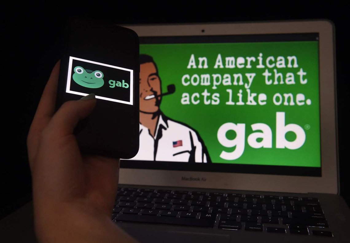 This illustration picture shows social media application logo from Gab displayed on a smart phone with its website in the background in Arlington, Virginia on January 11, 2021. (Photo by Olivier DOULIERY / AFP) This illustration picture shows social media application logo from Gab displayed on a smart phone with its website in the background in Arlington, Virginia on January 11, 2021. (Photo by Olivier DOULIERY / AFP)