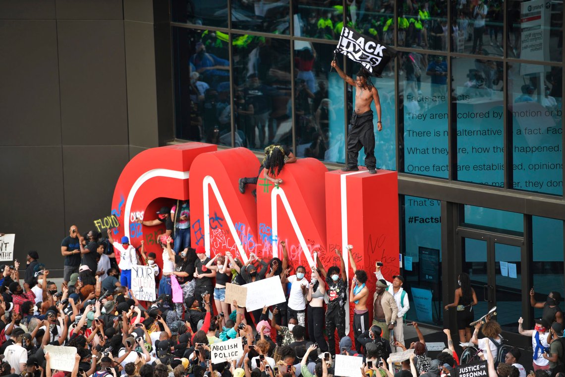 EDS NOTE: OBSCENITY - Demonstrators paint on the CNN logo during a protest, Friday, May 29, 2020, in Atlanta, in response to the death of George Floyd in police custody on Memorial Day in Minneapolis. The protest started peacefully earlier in the day before demonstrators clashed with police. (AP Photo/Mike Stewart) EDS NOTE: OBSCENITY - Demonstrators paint on the CNN logo during a protest, Friday, May 29, 2020, in Atlanta, in response to the death of George Floyd in police custody on Memorial Day in Minneapolis. The protest started peacefully earlier in the day before demonstrators clashed with police. (AP Photo/Mike Stewart)