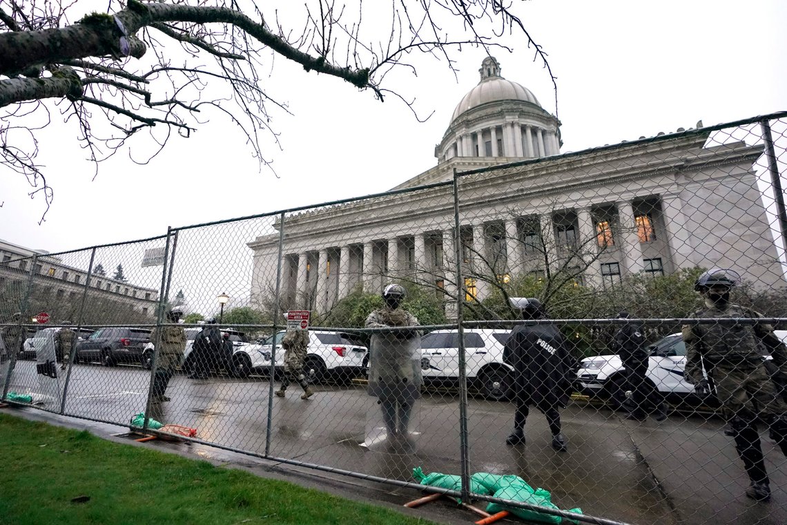 Members of the Washington National Guard stand near a fence surrounding the Capitol in anticipation of protests Monday, Jan. 11, 2021, in Olympia, Wash. State capitols across the country are under heightened security after the siege of the U.S. Capitol last week. (AP Photo/Ted S. Warren) Members of the Washington National Guard stand near a fence surrounding the Capitol in anticipation of protests Monday, Jan. 11, 2021, in Olympia, Wash. State capitols across the country are under heightened security after the siege of the U.S. Capitol last week. (AP Photo/Ted S. Warren)