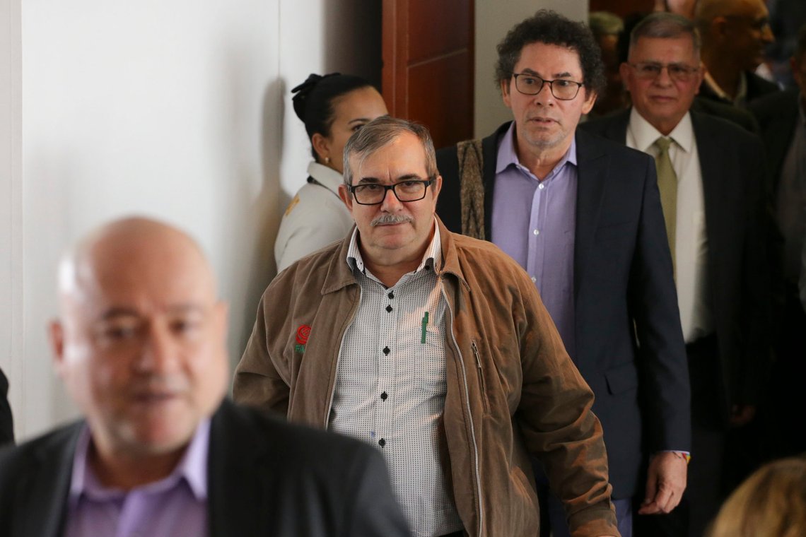 FILE - In this Sept. 23, 2019 file photo, former rebel top leader Rodrigo Londoño leaves the courtroom, followed by FARC former commander Pastor Alape, after appearing before Colombia's special peace tribunal to testify in an ongoing probe of their role in civilian kidnappings in Bogota, Colombia. The tribunal has charged eight former FARC commanders on Thursday, Jan. 28, 2021, with war crimes and crimes against humanity. Londoño and Alape are among those being charged. (AP Photo/Ivan Valencia, File) FILE - In this Sept. 23, 2019 file photo, former rebel top leader Rodrigo Londoño leaves the courtroom, followed by FARC former commander Pastor Alape, after appearing before Colombia's special peace tribunal to testify in an ongoing probe of their role in civilian kidnappings in Bogota, Colombia. The tribunal has charged eight former FARC commanders on Thursday, Jan. 28, 2021, with war crimes and crimes against humanity. Londoño and Alape are among those being charged. (AP Photo/Ivan Valencia, File)