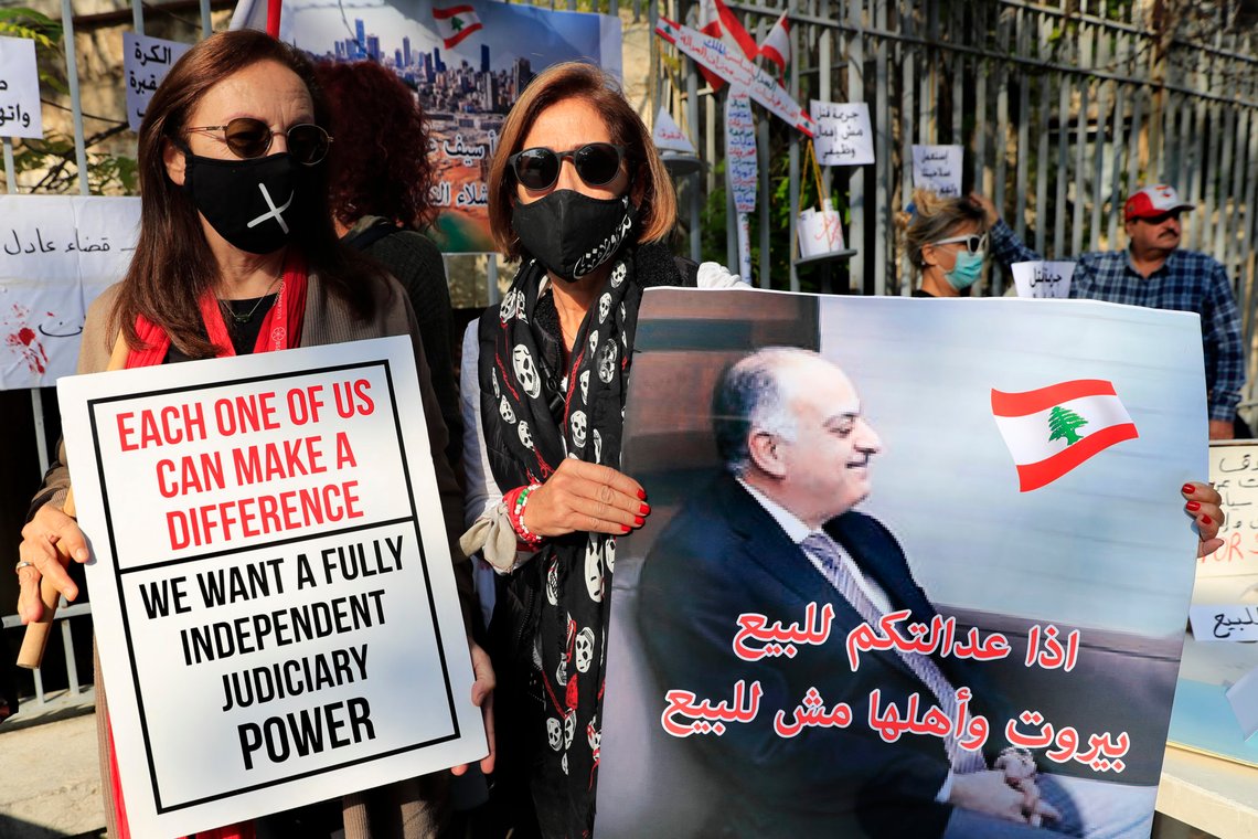 A Lebanese activists holds a placard showing a portrait of Lebanese judge Fadi Sawan who is in charge of the investigation of the August explosion in Beirut, with Arabic that reads: "if your justice is for sale, Beirut and its people not for sale," during a protest outside the justice palace, in Beirut, Lebanon, Thursday, Dec. 3, 2020. The blast was one of the largest non-nuclear explosions in history and six months later, political and confessional rivalries have undermined the probe into the Beirut port explosion and brought it to a virtual halt, mirroring the same rivalries that have thwarted past attempts to investigate political crimes throughout Lebanon's history. (AP Photo/Hussein Malla) A Lebanese activists holds a placard showing a portrait of Lebanese judge Fadi Sawan who is in charge of the investigation of the August explosion in Beirut, with Arabic that reads: "if your justice is for sale, Beirut and its people not for sale," during a protest outside the justice palace, in Beirut, Lebanon, Thursday, Dec. 3, 2020. The blast was one of the largest non-nuclear explosions in history and six months later, political and confessional rivalries have undermined the probe into the Beirut port explosion and brought it to a virtual halt, mirroring the same rivalries that have thwarted past attempts to investigate political crimes throughout Lebanon's history. (AP Photo/Hussein Malla)