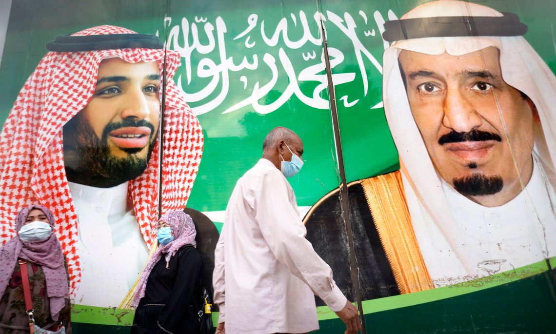 People wear face masks to protect against the spread of the coronavirus in front of a banner showing Saudi King Salman, right, and his Crown Prince Mohammed bin Salman, outside a mall in Jiddah, Saudi Arabia, Friday, Feb. 5, 2021. In Saudi Arabia, where authorities already have banned travel to the kingdom from 20 countries including the U.S., officials ordered all weddings and parties suspended. It closed down all shopping malls, gyms and other locations for 10 days, as well as indoor dining. (AP Photo/Amr Nabil) People wear face masks to protect against the spread of the coronavirus in front of a banner showing Saudi King Salman, right, and his Crown Prince Mohammed bin Salman, outside a mall in Jiddah, Saudi Arabia, Friday, Feb. 5, 2021. In Saudi Arabia, where authorities already have banned travel to the kingdom from 20 countries including the U.S., officials ordered all weddings and parties suspended. It closed down all shopping malls, gyms and other locations for 10 days, as well as indoor dining. (AP Photo/Amr Nabil)