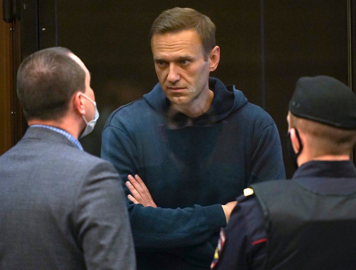 In this handout photo provided by Moscow City Court Russian opposition leader Alexei Navalny talks to one of his lawyers, left, while standing in the cage during a hearing to a motion from the Russian prison service to convert the suspended sentence of Navalny from the 2014 criminal conviction into a real prison term in the Moscow City Court in Moscow, Russia, Tuesday, Feb. 2, 2021. (Moscow City Court via AP) In this handout photo provided by Moscow City Court Russian opposition leader Alexei Navalny talks to one of his lawyers, left, while standing in the cage during a hearing to a motion from the Russian prison service to convert the suspended sentence of Navalny from the 2014 criminal conviction into a real prison term in the Moscow City Court in Moscow, Russia, Tuesday, Feb. 2, 2021. (Moscow City Court via AP)