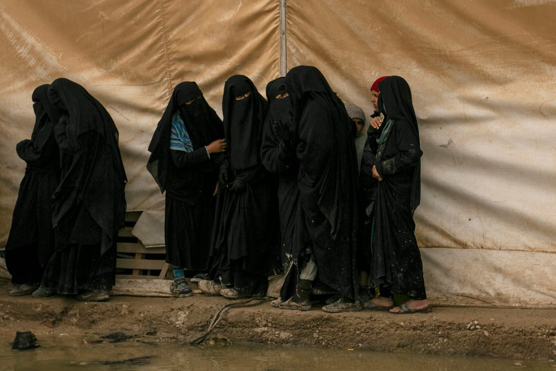 FILE - In this March 31, 2019, file, photo, women queue for aid supplies at al-Hol camp, home to Islamic State-affiliated families near Hasakeh, Syria. As Turkish troops invade northern Syria and the U.S. abandons its Kurdish allies, there are renewed fears of a prison break in the camp that could give new life to the extremist group. The Kurdish-led Syrian Democratic Forces are mobilizing to stop the Turkish invasion and say they may not be able to spare enough forces to secure al-Hol, home to tens of thousands of IS-linked women and their children. (AP Photo/Maya Alleruzzo, File) FILE - In this March 31, 2019, file, photo, women queue for aid supplies at al-Hol camp, home to Islamic State-affiliated families near Hasakeh, Syria. As Turkish troops invade northern Syria and the U.S. abandons its Kurdish allies, there are renewed fears of a prison break in the camp that could give new life to the extremist group. The Kurdish-led Syrian Democratic Forces are mobilizing to stop the Turkish invasion and say they may not be able to spare enough forces to secure al-Hol, home to tens of thousands of IS-linked women and their children. (AP Photo/Maya Alleruzzo, File)