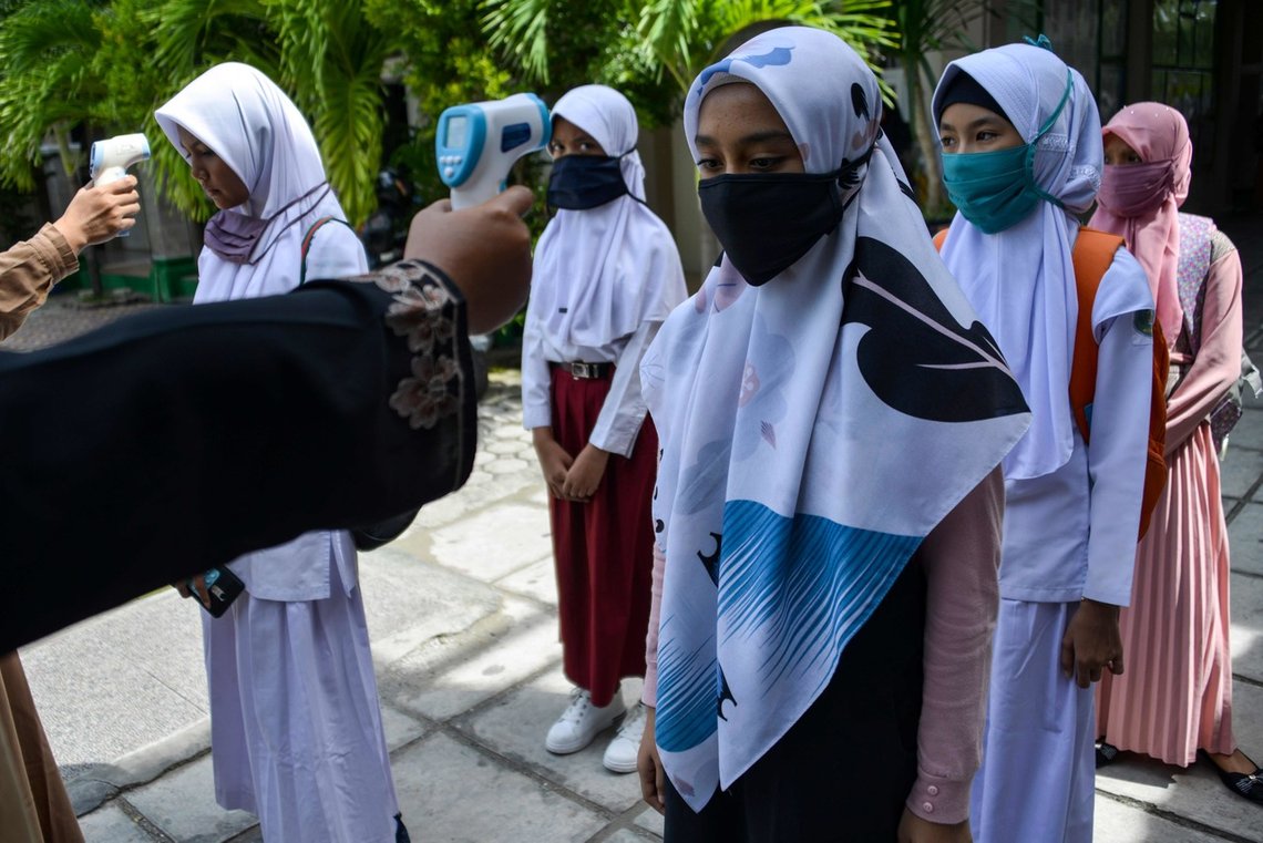 (FILES) This file photo taken on June 10, 2020 shows students queueing up to get their temperature taken at a junior high school in Banda Aceh. - Indonesia has banned schools from forcing girls to wear Islamic "hijab" headscarves after the case of a Christian pupil pressured to cover up sparked outrage in the world's most populous Muslim nation. (Photo by CHAIDEER MAHYUDDIN / AFP) (FILES) This file photo taken on June 10, 2020 shows students queueing up to get their temperature taken at a junior high school in Banda Aceh. - Indonesia has banned schools from forcing girls to wear Islamic "hijab" headscarves after the case of a Christian pupil pressured to cover up sparked outrage in the world's most populous Muslim nation. (Photo by CHAIDEER MAHYUDDIN / AFP)