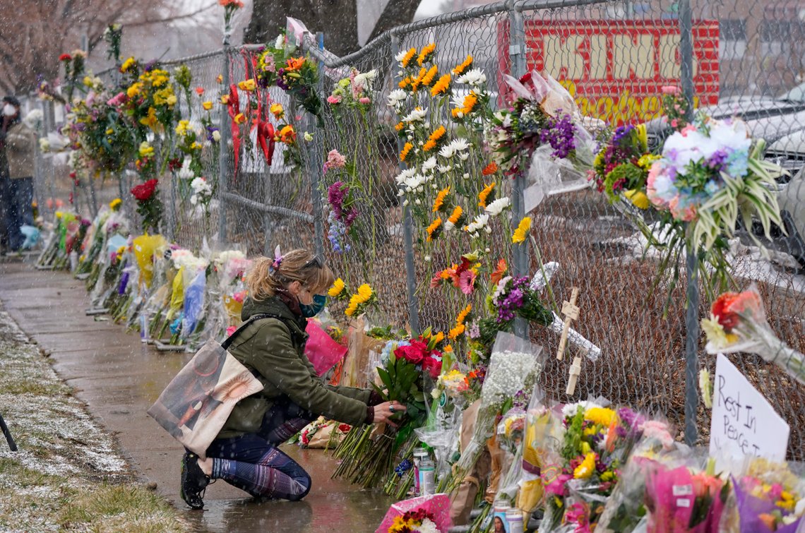 A mourner leaves a bouquet of flowers along a fence put up around the parking lot where a mass shooting took place in a King Soopers grocery store Tuesday, March 23, 2021, in Boulder, Colo. (AP Photo/David Zalubowski) A mourner leaves a bouquet of flowers along a fence put up around the parking lot where a mass shooting took place in a King Soopers grocery store Tuesday, March 23, 2021, in Boulder, Colo. (AP Photo/David Zalubowski)