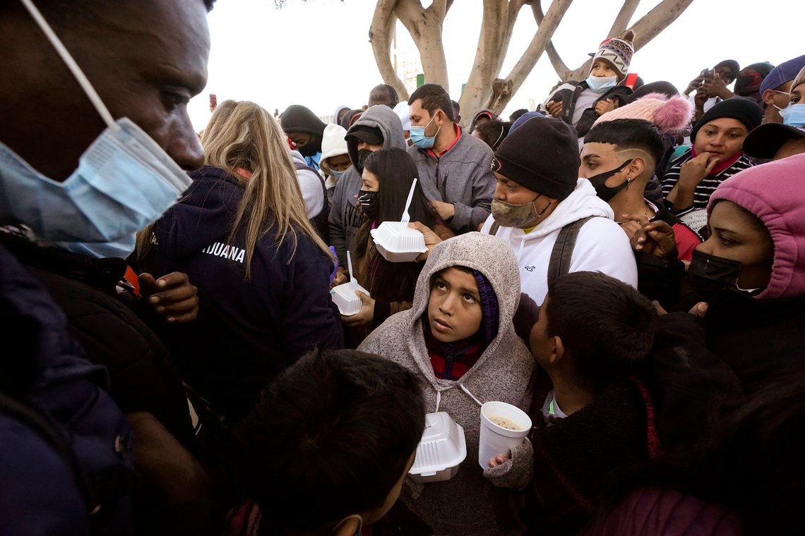 Asylum seekers receive food as they wait for news of policy changes at the border, Friday, Feb. 19, 2021, in Tijuana, Mexico. After waiting months and sometimes years in Mexico, people seeking asylum in the United States are being allowed into the country starting Friday as they wait for courts to decide on their cases, unwinding one of the Trump administration's signature immigration policies that President Joe Biden vowed to end. (AP Photo/Gregory Bull) Asylum seekers receive food as they wait for news of policy changes at the border, Friday, Feb. 19, 2021, in Tijuana, Mexico. After waiting months and sometimes years in Mexico, people seeking asylum in the United States are being allowed into the country starting Friday as they wait for courts to decide on their cases, unwinding one of the Trump administration's signature immigration policies that President Joe Biden vowed to end. (AP Photo/Gregory Bull)