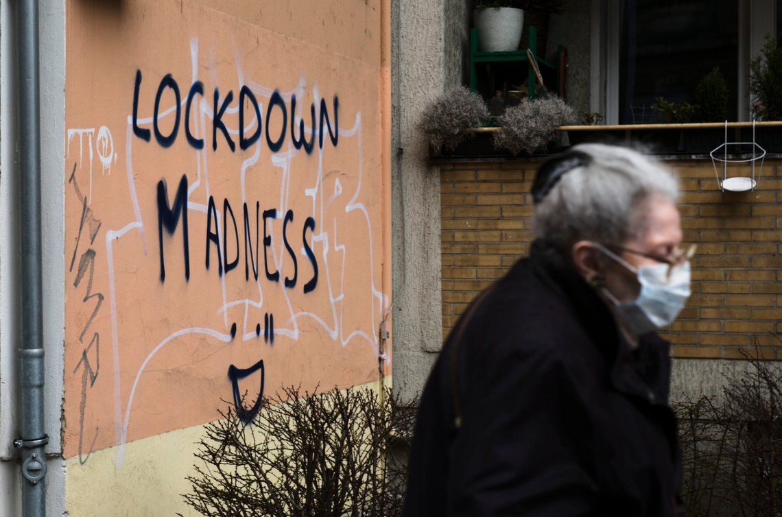 A pedestrian walks by grafitti reading "Lockdown Madness" in the district Schoeneberg in Berlin, Germany, Tuesday, March 23, 2021. Germany extended its lockdown measures by another month and imposed several new restrictions, including largely shutting down public life over Easter, in an effort to drive down the rate of coronavirus infections. (AP Photo/Markus Schreiber) A pedestrian walks by grafitti reading "Lockdown Madness" in the district Schoeneberg in Berlin, Germany, Tuesday, March 23, 2021. Germany extended its lockdown measures by another month and imposed several new restrictions, including largely shutting down public life over Easter, in an effort to drive down the rate of coronavirus infections. (AP Photo/Markus Schreiber)