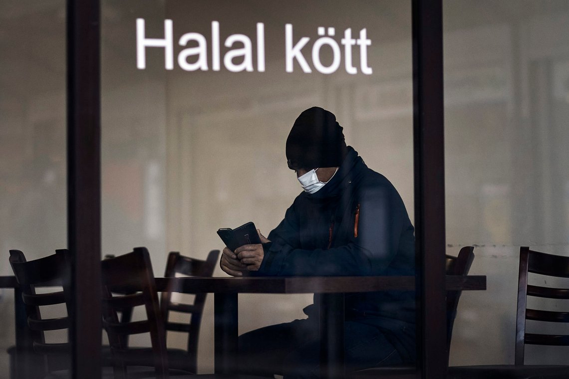 A man sits at a restaurant in Rinkeby district, Rinkeby-Kista borough in Stockholm, Sweden, Tuesday, April 28, 2020. The coronavirus has taken a disproportionate toll among Sweden's immigrants. Many in these communities are more likely to live in crowded households and are unable to work remotely. There also are concerns the message has not reached everyone in immigrant neighborhoods. (AP Photo/Andres Kudacki) A man sits at a restaurant in Rinkeby district, Rinkeby-Kista borough in Stockholm, Sweden, Tuesday, April 28, 2020. The coronavirus has taken a disproportionate toll among Sweden's immigrants. Many in these communities are more likely to live in crowded households and are unable to work remotely. There also are concerns the message has not reached everyone in immigrant neighborhoods. (AP Photo/Andres Kudacki)
