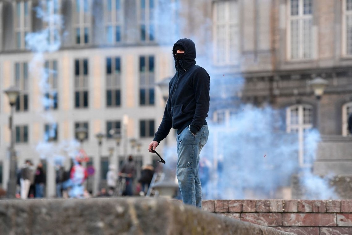 A man with the face covered stands among the smoke as clashes between protestors and the police erupted on the sidelines of a Black Lives Matter demonstration, in the centre of Liege, eastern Belgium, on March 13, 2021 - Several police officers were wounded when violence and looting broke out on the sidelines of a Black Lives Matter demonstration in the eastern Belgian city of Liege on March 13, 2021, police said. The march was held to protest against the arrest of a woman for "rebellion" in the city at the begining of the week, who has since accused the police of racism, a police spokeswoman said. (Photo by JOHN THYS / AFP) A man with the face covered stands among the smoke as clashes between protestors and the police erupted on the sidelines of a Black Lives Matter demonstration, in the centre of Liege, eastern Belgium, on March 13, 2021 - Several police officers were wounded when violence and looting broke out on the sidelines of a Black Lives Matter demonstration in the eastern Belgian city of Liege on March 13, 2021, police said. The march was held to protest against the arrest of a woman for "rebellion" in the city at the begining of the week, who has since accused the police of racism, a police spokeswoman said. (Photo by JOHN THYS / AFP)