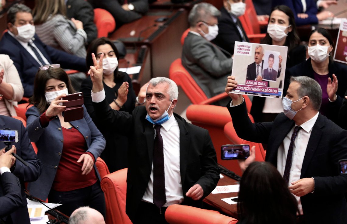 Omer Faruk Gergerlioglu, a human rights advocate and lawmaker from the People's Democratic Party, or HDP, center, reacts after the parliament stripped his parliamentary seat, in Ankara, Turkey, Wednesday, March 17, 2021. In the latest crackdown on Turkey's pro-Kurdish opposition party, Turkey on Wednesday stripped a prominent legislator of his parliamentary seat following his conviction over a 2016 social media post. The legislator protested the move and refused to vacate parliament.(AP Photo) Omer Faruk Gergerlioglu, a human rights advocate and lawmaker from the People's Democratic Party, or HDP, center, reacts after the parliament stripped his parliamentary seat, in Ankara, Turkey, Wednesday, March 17, 2021. In the latest crackdown on Turkey's pro-Kurdish opposition party, Turkey on Wednesday stripped a prominent legislator of his parliamentary seat following his conviction over a 2016 social media post. The legislator protested the move and refused to vacate parliament.(AP Photo)