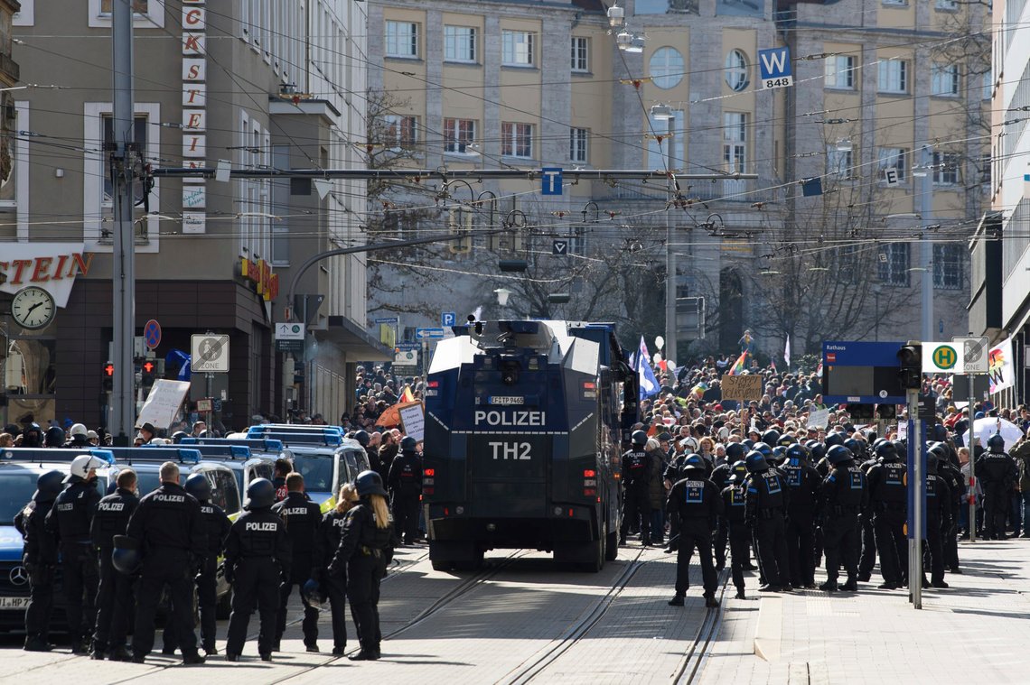 Police forces stand next to a water canon during a rally under the motto "Free citizens Kassel - basic rights and democracy" i Kassel, Germany, Saturday, March 20, 2021. According to police, several thousand people were on the move in the city center and disregarded the instructions of the authorities during the unregistered demonstration against Corona measures. (Swen Pfoertner/dpa via AP) Police forces stand next to a water canon during a rally under the motto "Free citizens Kassel - basic rights and democracy" i Kassel, Germany, Saturday, March 20, 2021. According to police, several thousand people were on the move in the city center and disregarded the instructions of the authorities during the unregistered demonstration against Corona measures. (Swen Pfoertner/dpa via AP)
