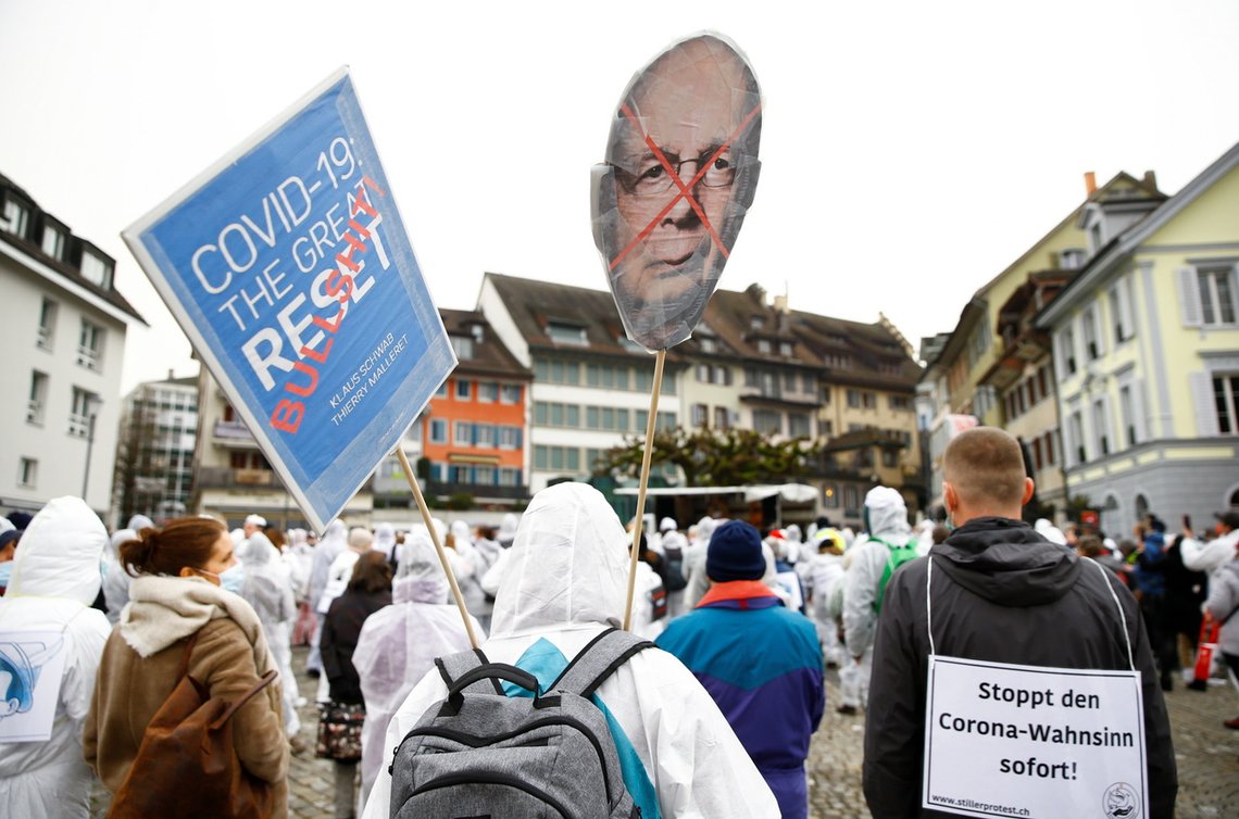 A demonstrator holds a sign depicting World Economic Forum founder Klaus Schwab during a protest amid the coronavirus disease (COVID-19) pandemic in Zug, Switzerland, February 6, 2021. REUTERS/Arnd Wiegmann A demonstrator holds a sign depicting World Economic Forum founder Klaus Schwab during a protest amid the coronavirus disease (COVID-19) pandemic in Zug, Switzerland, February 6, 2021. REUTERS/Arnd Wiegmann