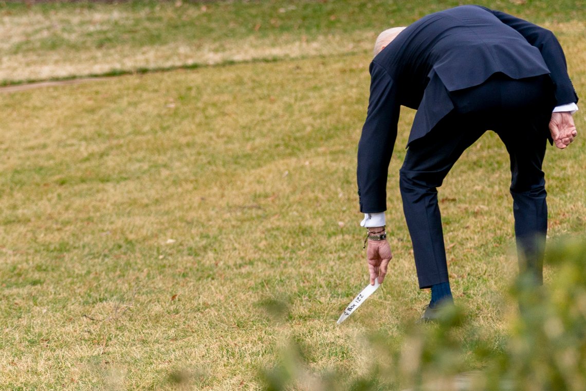 President Joe Biden stops to pick something up in the grass on the South Lawn of the White House in Washington, Wednesday, March 17, 2021, after returning from Wilmington, Del. (AP Photo/Andrew Harnik) President Joe Biden stops to pick something up in the grass on the South Lawn of the White House in Washington, Wednesday, March 17, 2021, after returning from Wilmington, Del. (AP Photo/Andrew Harnik)