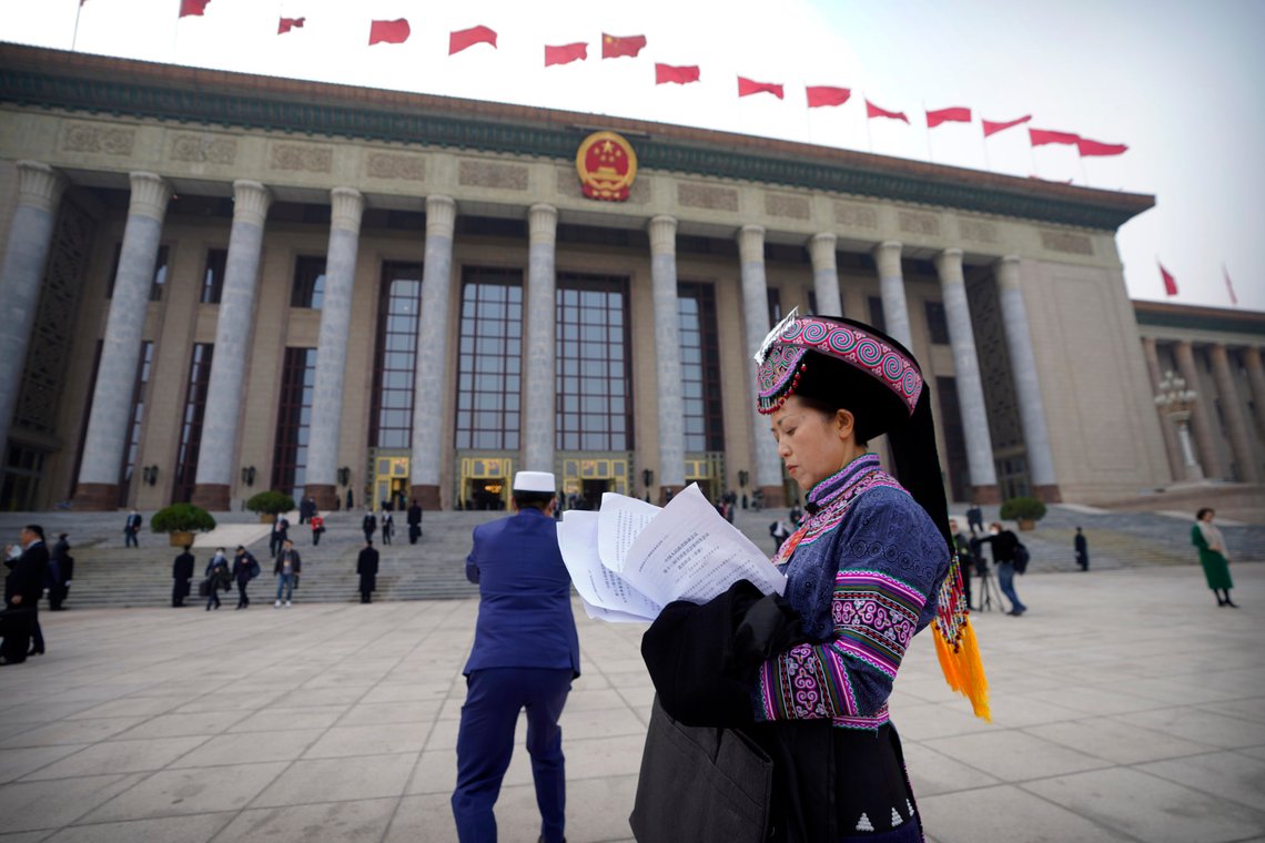 A delegate in ethnic minority dress looks at paperwork outside of the Great Hall of the People after the closing session of the Chinese People's Political Consultative Conference (CPPCC) in Beijing, Wednesday, March 10, 2021. (AP Photo/Mark Schiefelbein) A delegate in ethnic minority dress looks at paperwork outside of the Great Hall of the People after the closing session of the Chinese People's Political Consultative Conference (CPPCC) in Beijing, Wednesday, March 10, 2021. (AP Photo/Mark Schiefelbein)