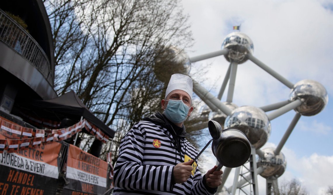 A man in a prison costume bangs on a pot during a demonstration against COVID-19 restrictions on restaurants and bars in front of the Atomium landmark in Brussels, Monday, March 15, 2021. Restaurant owners and workers are calling for an end to the lockdown and restrictions on their industry, which has been closed to in-person dining since October 2020. (AP Photo/Virginia Mayo) A man in a prison costume bangs on a pot during a demonstration against COVID-19 restrictions on restaurants and bars in front of the Atomium landmark in Brussels, Monday, March 15, 2021. Restaurant owners and workers are calling for an end to the lockdown and restrictions on their industry, which has been closed to in-person dining since October 2020. (AP Photo/Virginia Mayo)