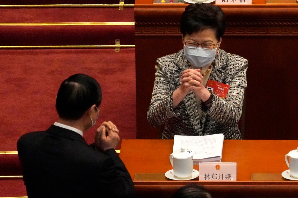 Hong Kong Chief Executive Carrie Lam, right, exchanges greetings with a fellow delegate before the opening session of China's National People's Congress (NPC) at the Great Hall of the People in Beijing, Friday, March 5, 2021. (AP Photo/Andy Wong) Hong Kong Chief Executive Carrie Lam, right, exchanges greetings with a fellow delegate before the opening session of China's National People's Congress (NPC) at the Great Hall of the People in Beijing, Friday, March 5, 2021. (AP Photo/Andy Wong)