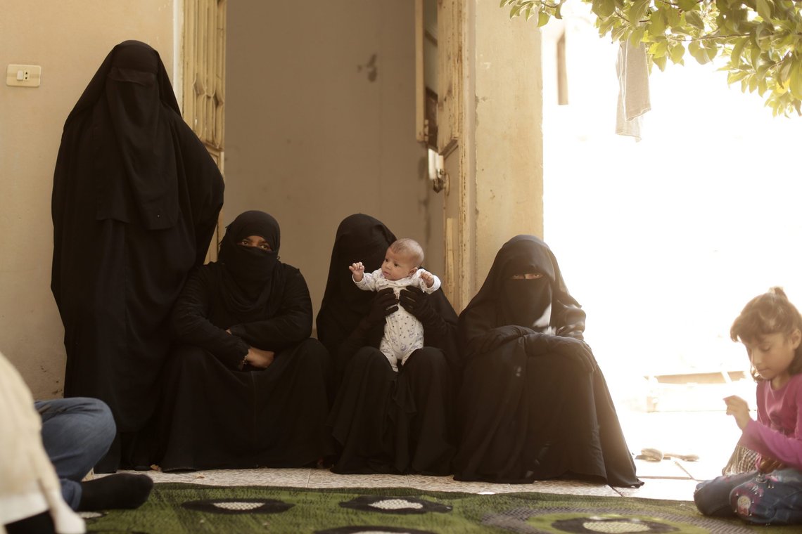 In this Saturday, Sept. 7, 2019, photo, women who recently returned from Al-Hol camp, which holds families of Islamic State members, gather in the courtyard of their home in Raqqa, Syria, during an interview. The Kurdish-led administration has coordinated with Arab tribal sheiks to secure the return of nearly 700 families to Raqqa from al-Hol camp. The tribal leaders vouched for the returnees, acting as guarantee that they will not cause trouble. Thousands have applied to return from the sprawling camp which hosts nearly 30,000 Syrians, mostly women and children. (AP Photo/Maya Alleruzzo) In this Saturday, Sept. 7, 2019, photo, women who recently returned from Al-Hol camp, which holds families of Islamic State members, gather in the courtyard of their home in Raqqa, Syria, during an interview. The Kurdish-led administration has coordinated with Arab tribal sheiks to secure the return of nearly 700 families to Raqqa from al-Hol camp. The tribal leaders vouched for the returnees, acting as guarantee that they will not cause trouble. Thousands have applied to return from the sprawling camp which hosts nearly 30,000 Syrians, mostly women and children. (AP Photo/Maya Alleruzzo)