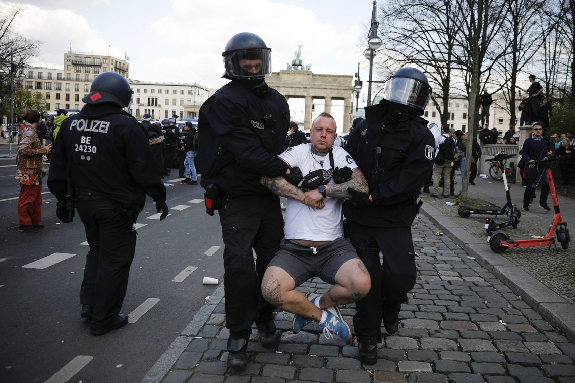 Politiet arresterer tyskere i Berlin som protesterer mot mer makt til føderale tyske myndigheter til å innføre portforbud for å bekjempe koronavirus. 21. april 2021, fotografi av Markus Schreiber, AP-NTB. Politiet arresterer tyskere i Berlin som protesterer mot mer makt til føderale tyske myndigheter til å innføre portforbud for å bekjempe koronavirus. 21. april 2021, fotografi av Markus Schreiber, AP-NTB.