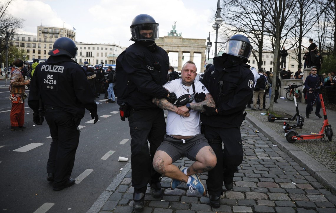 Police officers carry away a demonstrator after police stop a protest rally against the German government's policy to battle the corona virus pandemic near the Brandenburg Gate in Berlin, Germany, Wednesday, April 21, 2021.The parliament decides on a law that gives the federal government more power to battle the coronavirus pandemic. (AP Photo/Markus Schreiber) Police officers carry away a demonstrator after police stop a protest rally against the German government's policy to battle the corona virus pandemic near the Brandenburg Gate in Berlin, Germany, Wednesday, April 21, 2021.The parliament decides on a law that gives the federal government more power to battle the coronavirus pandemic. (AP Photo/Markus Schreiber)