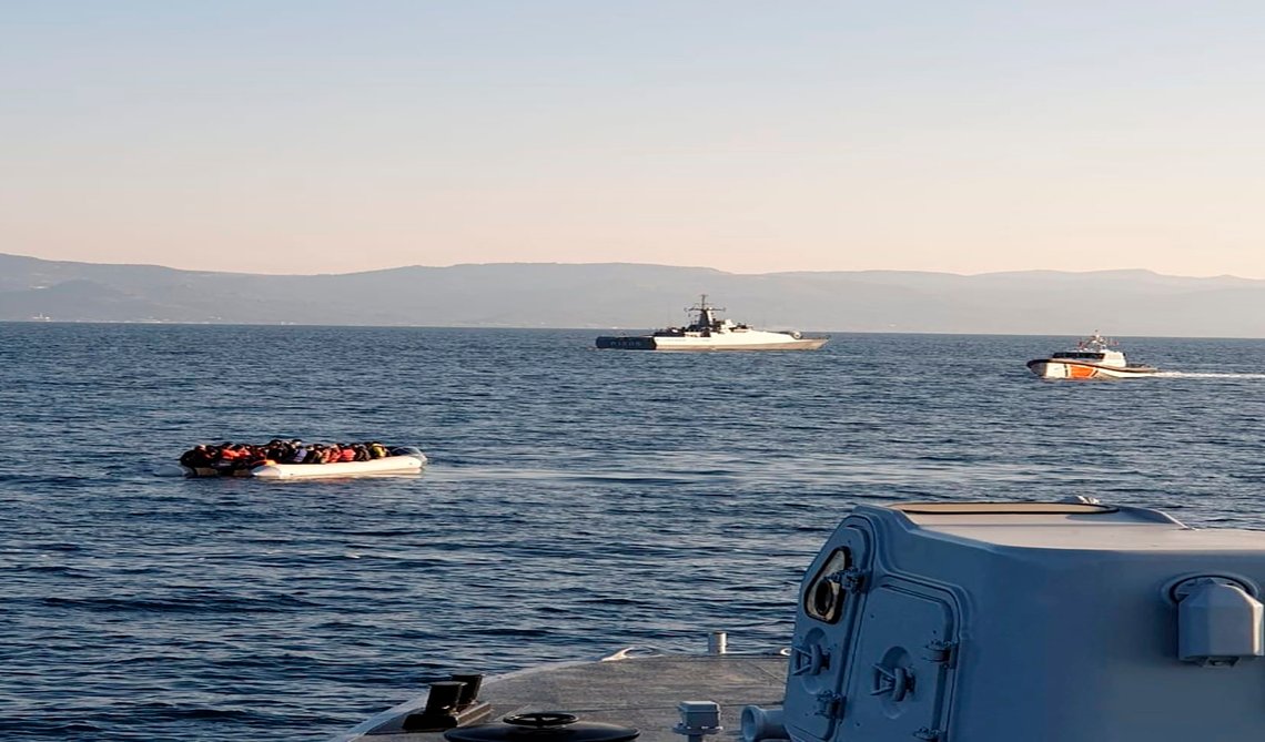 Her sees en båt fylt med migranter, med tyrkiske skip i bakgrunnen, på den smale strekningen av vann mellom den østlige greske øya Lesvos og den tyrkiske kysten, fredag, 2. april, 2021. Nå anklager greske myndigheter ti utlendinger, derav en norsk, for ulovlig å ha fasilitert slike transporter. Foto: Gresk kystvakt / AP / NTB Her sees en båt fylt med migranter, med tyrkiske skip i bakgrunnen, på den smale strekningen av vann mellom den østlige greske øya Lesvos og den tyrkiske kysten, fredag, 2. april, 2021. Nå anklager greske myndigheter ti utlendinger, derav en norsk, for ulovlig å ha fasilitert slike transporter. Foto: Gresk kystvakt / AP / NTB