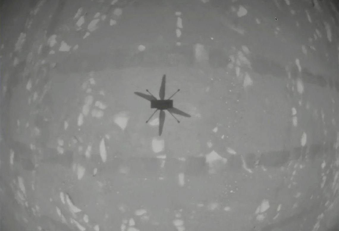 In this image from NASA, the experimental Mars helicopter Ingenuity casts a shadow as it hovers above the surface of the planet on Monday, April 19, 2021. The little 4-pound helicopter rose from the dusty red surface into the thin Martian air Monday, achieving the first powered, controlled flight on another planet. (NASA via AP) In this image from NASA, the experimental Mars helicopter Ingenuity casts a shadow as it hovers above the surface of the planet on Monday, April 19, 2021. The little 4-pound helicopter rose from the dusty red surface into the thin Martian air Monday, achieving the first powered, controlled flight on another planet. (NASA via AP)