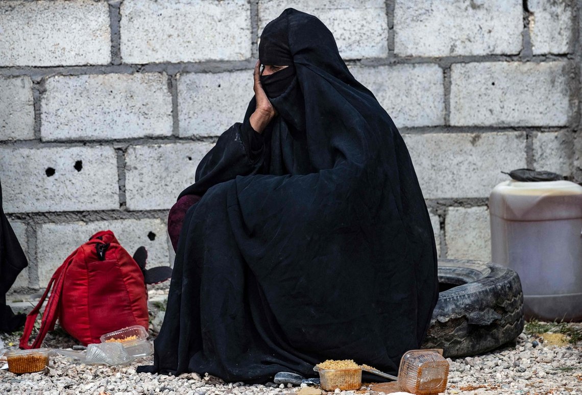 A Syrian woman awaits departure by her belongings as another group of Syrian families is released from the Kurdish-run al-Hol camp which holds suspected relatives of Islamic State (IS) group fighters, in Hasakeh governorate of northeastern Syria, on March 18, 2021. (Photo by Delil SOULEIMAN / AFP) A Syrian woman awaits departure by her belongings as another group of Syrian families is released from the Kurdish-run al-Hol camp which holds suspected relatives of Islamic State (IS) group fighters, in Hasakeh governorate of northeastern Syria, on March 18, 2021. (Photo by Delil SOULEIMAN / AFP)