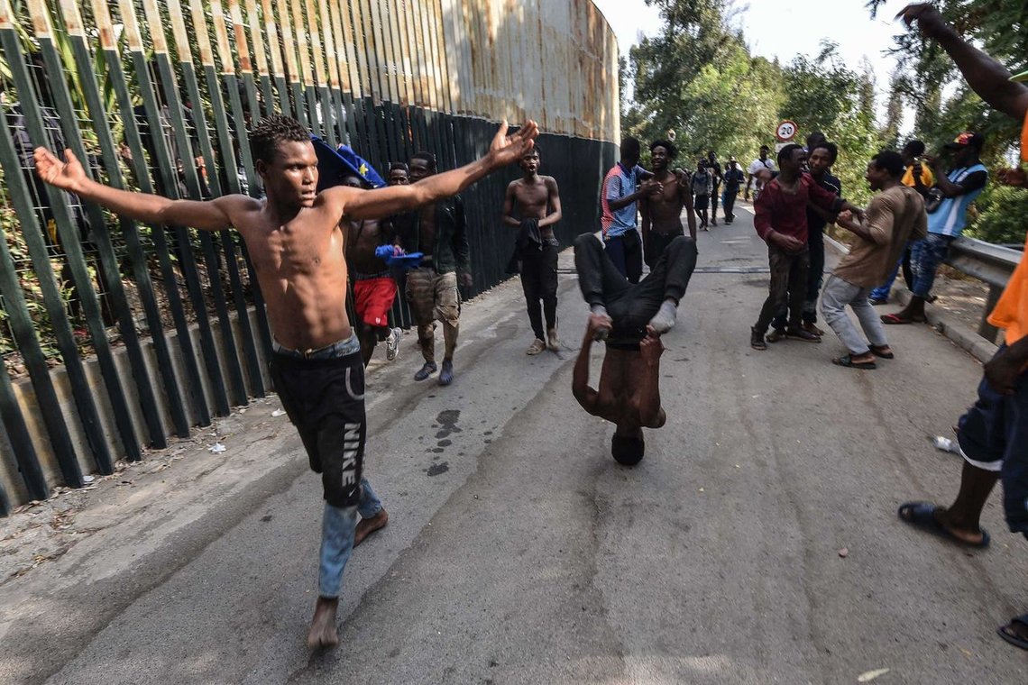 A group of men celebrate after forcing their way into the Spanish territory of Ceuta on August 22, 2018. - The migrants made their way into Ceuta after storming a barbed-wire border fence with Morocco and attacking police with caustic quicklime, a local official said. (Photo by Joaquin SANCHEZ / AFP) A group of men celebrate after forcing their way into the Spanish territory of Ceuta on August 22, 2018. - The migrants made their way into Ceuta after storming a barbed-wire border fence with Morocco and attacking police with caustic quicklime, a local official said. (Photo by Joaquin SANCHEZ / AFP)