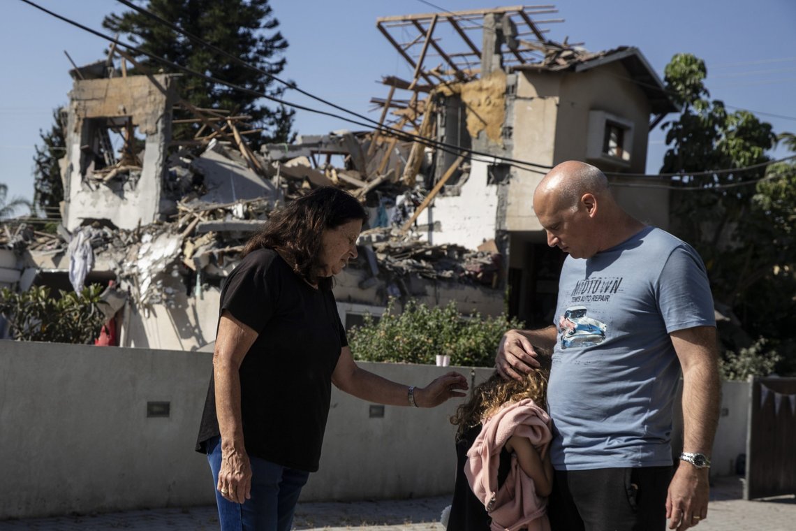 A young girl is comforted by her father next to a house damaged by a rocket fired from the Gaza Strip, in Yehod, central Israel, Wednesday, May 12, 2021. The house was hit on May 11, as barrage of rockets fired from the Gaza Strip toward central Israel. (AP Photo/Heidi Levine) A young girl is comforted by her father next to a house damaged by a rocket fired from the Gaza Strip, in Yehod, central Israel, Wednesday, May 12, 2021. The house was hit on May 11, as barrage of rockets fired from the Gaza Strip toward central Israel. (AP Photo/Heidi Levine)