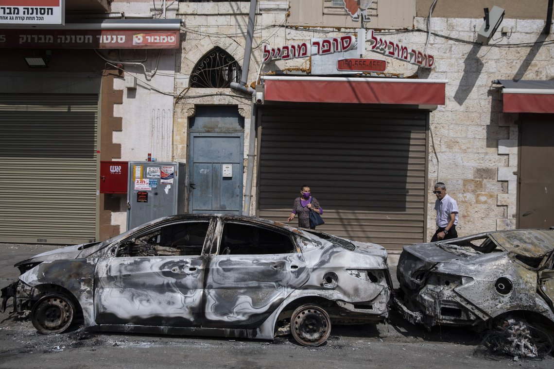 People are looking at cars torched after a night of violence between Israeli Arab protesters and Israeli police in the mixed Arab-Jewish town of Lod, central Israel, Tuesday, May 11, 2021. (AP Photo/Heidi Levine) People are looking at cars torched after a night of violence between Israeli Arab protesters and Israeli police in the mixed Arab-Jewish town of Lod, central Israel, Tuesday, May 11, 2021. (AP Photo/Heidi Levine)