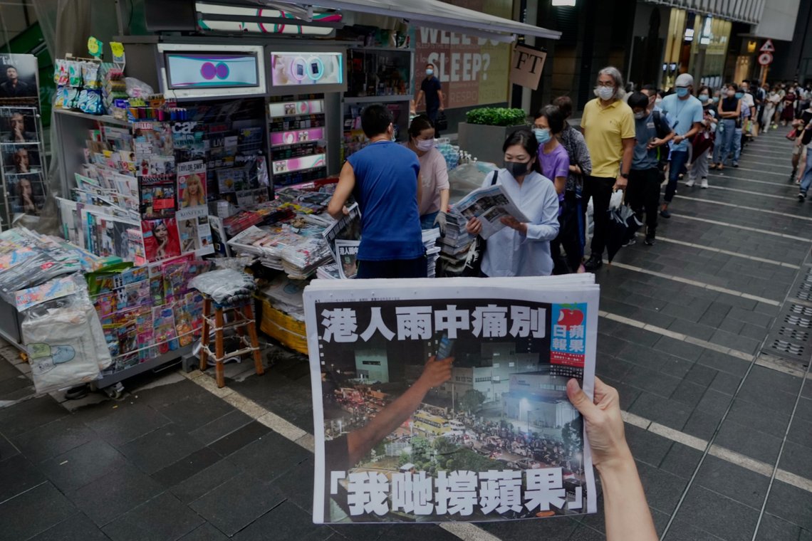 A woman tries to take a picture of last issue of Apple Daily in front of a newspaper booth where people queue up to buy the newspaper at a downtown street in Hong Kong, Thursday, June 24, 2021. Hong Kong's sole remaining pro-democracy newspaper has published its last edition. Apple Daily was forced to shut down Thursday after five editors and executives were arrested and millions of dollars in its assets were frozen as part of China's increasing crackdown on dissent in the semi-autonomous city. ( AP Photo/Vincent Yu) A woman tries to take a picture of last issue of Apple Daily in front of a newspaper booth where people queue up to buy the newspaper at a downtown street in Hong Kong, Thursday, June 24, 2021. Hong Kong's sole remaining pro-democracy newspaper has published its last edition. Apple Daily was forced to shut down Thursday after five editors and executives were arrested and millions of dollars in its assets were frozen as part of China's increasing crackdown on dissent in the semi-autonomous city. ( AP Photo/Vincent Yu)