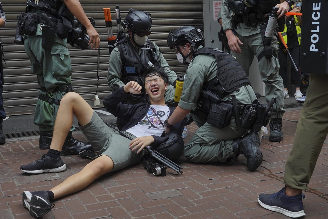 En journalist går i bakken etter å ha blitt sprayet med pepperspray under protestmarsjen 1. juli i fjor. Foto: Vincent Yu/AP/NTB En journalist går i bakken etter å ha blitt sprayet med pepperspray under protestmarsjen 1. juli i fjor. Foto: Vincent Yu/AP/NTB