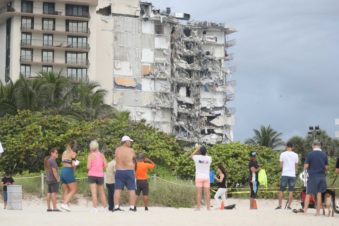 People look at the damage at the 12-story oceanfront Champlain Towers South Condo that collapsed early Thursday, June 24, 2021 in Surfside, Fla. People look at the damage at the 12-story oceanfront Champlain Towers South Condo that collapsed early Thursday, June 24, 2021 in Surfside, Fla.