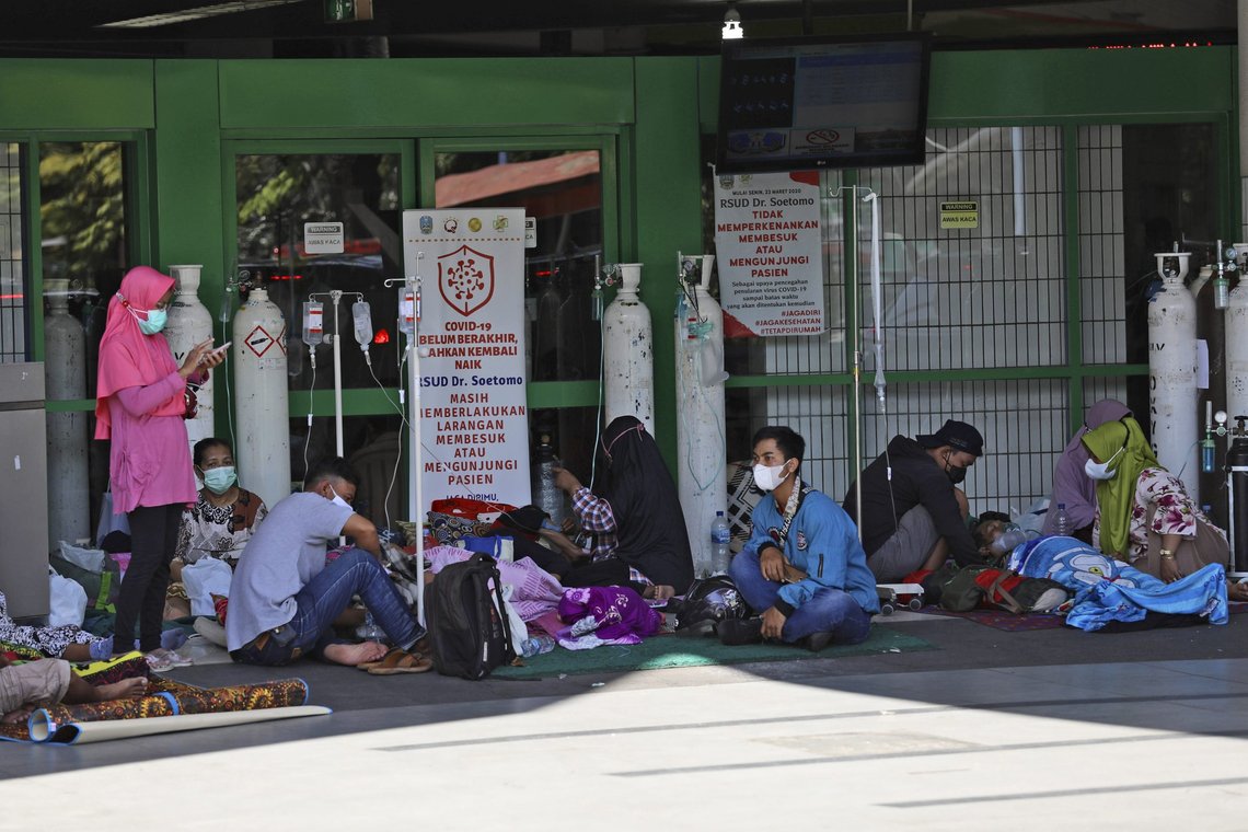 People sit on the floor outside the emergency ward of a hospital that cannot take any more patients amid a surge in COVID-19 cases in Surabaya, East Java, Indonesia, Sunday, July 11, 2021. The world's fourth-most populous country is battling an explosion of COVID-19 cases that have strained hospital on the main island of Java. (AP Photo/Trisnadi) People sit on the floor outside the emergency ward of a hospital that cannot take any more patients amid a surge in COVID-19 cases in Surabaya, East Java, Indonesia, Sunday, July 11, 2021. The world's fourth-most populous country is battling an explosion of COVID-19 cases that have strained hospital on the main island of Java. (AP Photo/Trisnadi)