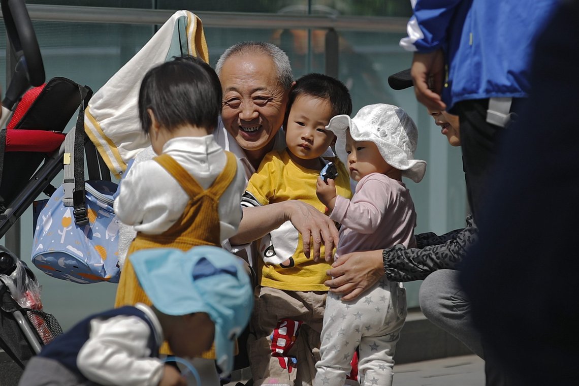 En eldre kinesisk mann leker med barn i Beijing, mai 2021. Foto: Andy Wong, AP-NTB. En eldre kinesisk mann leker med barn i Beijing, mai 2021. Foto: Andy Wong, AP-NTB.