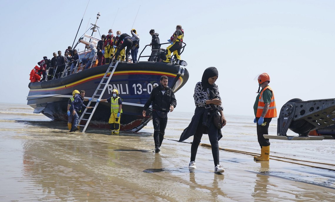 En gruppe migranter blir brakt i land på Dungeness, Sør-England, tirsdag 20. juli, 2021. Gruppen ble plukket opp av livbåten etter en «liten båthendelse» i den engelske kanalen. Foto: Gareth Fuller / PA via AP / NTB En gruppe migranter blir brakt i land på Dungeness, Sør-England, tirsdag 20. juli, 2021. Gruppen ble plukket opp av livbåten etter en «liten båthendelse» i den engelske kanalen. Foto: Gareth Fuller / PA via AP / NTB