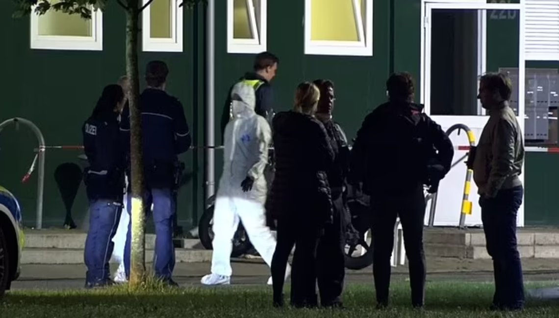 Politi og ansatte utenfor mottakssentere i Greven i Tyskland, hvor en migrant drepte en annen migrant med kniv, og såret en tysk statsborger. Skjermdump Daily Mail/ ukreditert Politi og ansatte utenfor mottakssentere i Greven i Tyskland, hvor en migrant drepte en annen migrant med kniv, og såret en tysk statsborger. Skjermdump Daily Mail/ ukreditert