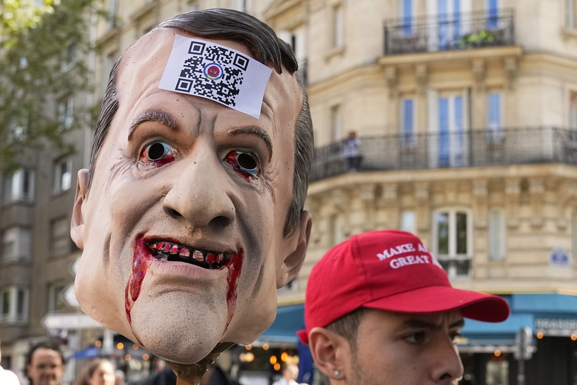 FILE - In this Saturday, July 31, 2021 file photo, a protestor holds a puppet head depicting French President Emmanuel Macron during a demonstration against the COVID-19 pass, which grants vaccinated individuals greater ease of access to venues, in Paris, France. French President Emmanuel Macron has taken to popular social media apps in a new push to encourage vaccinations against COVID-19, combat "false information" and reach out to younger people. Filming himself from his summer residency at Fort de Bregancon on the French Riviera wearing a casual T-shirt, Macron, 43, offered to answer people's questions in a video posted on Instagram and Tiktok. (AP Photo/Michel Euler, File) FILE - In this Saturday, July 31, 2021 file photo, a protestor holds a puppet head depicting French President Emmanuel Macron during a demonstration against the COVID-19 pass, which grants vaccinated individuals greater ease of access to venues, in Paris, France. French President Emmanuel Macron has taken to popular social media apps in a new push to encourage vaccinations against COVID-19, combat "false information" and reach out to younger people. Filming himself from his summer residency at Fort de Bregancon on the French Riviera wearing a casual T-shirt, Macron, 43, offered to answer people's questions in a video posted on Instagram and Tiktok. (AP Photo/Michel Euler, File)