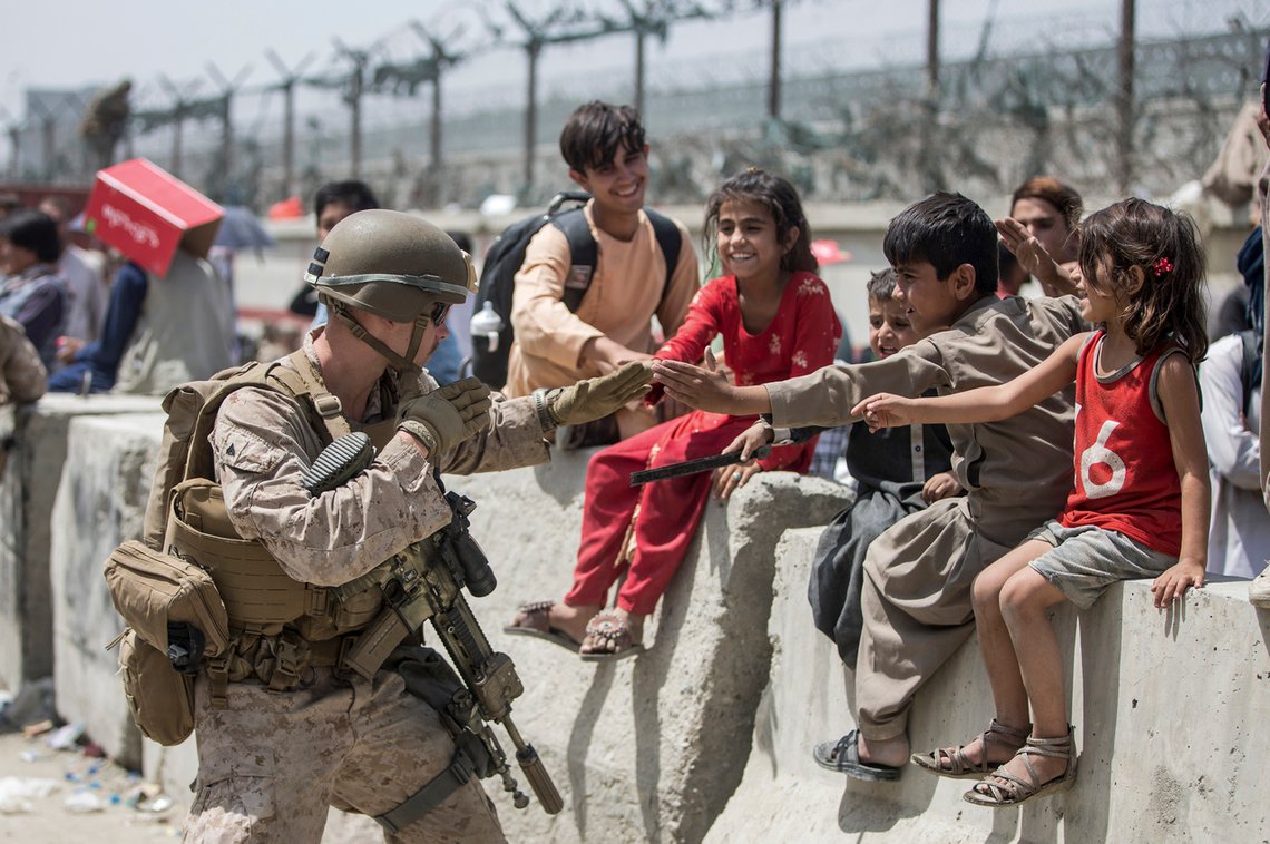En soldat fra U.S. Marine Corps får afghanske barn til å smile. Nå frykter man at IS-terrorister infiltrerer strømmen av afghanere som vil flykte landet. Foto: Sgt. Samuel Ruiz/ U.S. Marine Corps/ AP/ NTB En soldat fra U.S. Marine Corps får afghanske barn til å smile. Nå frykter man at IS-terrorister infiltrerer strømmen av afghanere som vil flykte landet. Foto: Sgt. Samuel Ruiz/ U.S. Marine Corps/ AP/ NTB