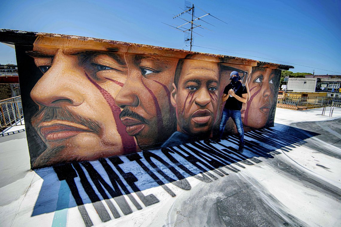 Street artist Jorit poses next to his last work, a mural honoring George Floyd, who died May 25 after being restrained by police in Minneapolis, USA, depicting from left, Lenin, Martin Luther King, George Floyd, Malcom X and Angela Davis, in Naples, southern Italy, Saturday, June 6, 2020. (Alessandro Pone/LaPresse via AP) Street artist Jorit poses next to his last work, a mural honoring George Floyd, who died May 25 after being restrained by police in Minneapolis, USA, depicting from left, Lenin, Martin Luther King, George Floyd, Malcom X and Angela Davis, in Naples, southern Italy, Saturday, June 6, 2020. (Alessandro Pone/LaPresse via AP)