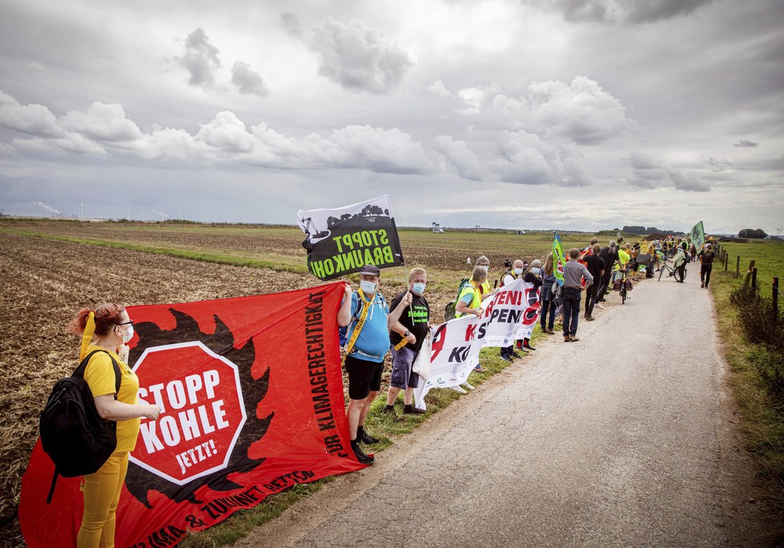 Environmental and climate activists as well as residents of neighbouring villages have form a human chain on the edge of the Garzweiler open-cast mine in Juechen, Germany, Saturday, Aug. 7, 2021. About 2,500 people have protested for a quick exit from coal mining in western Germany. They formed a four-kilometer (2.5-mile) human chain between the villages of Luetzerath and Keyenberg on Saturday. Protesters were campaigning to save Luetzerath from being bulldozed to make way for a coal mine. (Malte Krudewig/dpa via AP) Environmental and climate activists as well as residents of neighbouring villages have form a human chain on the edge of the Garzweiler open-cast mine in Juechen, Germany, Saturday, Aug. 7, 2021. About 2,500 people have protested for a quick exit from coal mining in western Germany. They formed a four-kilometer (2.5-mile) human chain between the villages of Luetzerath and Keyenberg on Saturday. Protesters were campaigning to save Luetzerath from being bulldozed to make way for a coal mine. (Malte Krudewig/dpa via AP)