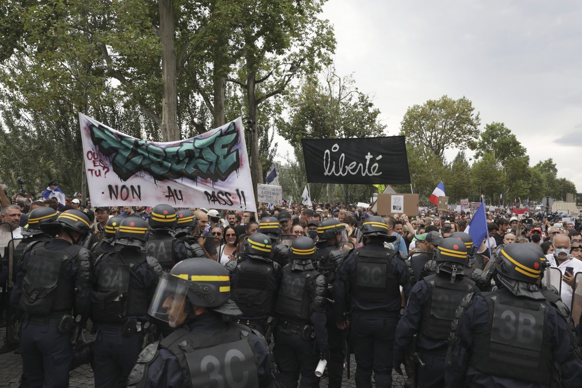 Protesters march with a baner reading "Freedom" during a demonstration against the health pass, Saturday, Aug. 21, 2021 in Paris. People denounce a COVID-19 health pass needed to access restaurant, long-distance trains and other venues. (AP Photo/Adrienne Surprenant) Protesters march with a baner reading "Freedom" during a demonstration against the health pass, Saturday, Aug. 21, 2021 in Paris. People denounce a COVID-19 health pass needed to access restaurant, long-distance trains and other venues. (AP Photo/Adrienne Surprenant)