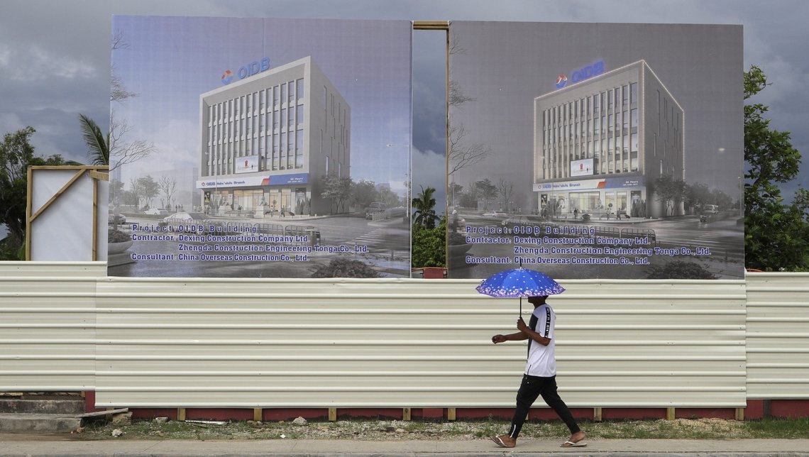 FILE - In this April 10, 2019, file photo, a man walks past a development site for a Chinese Investment bank in Nuku'alofa, Tonga. The Sydney-based think tank Lowy Institute released its annual Pacific Aid Map, Wednesday, Sept. 29, 2021, saying China gave significantly less aid to the Pacific in recent years despite Beijings diplomatic efforts to increase its influence in the region. (AP Photo/Mark Baker, File) FILE - In this April 10, 2019, file photo, a man walks past a development site for a Chinese Investment bank in Nuku'alofa, Tonga. The Sydney-based think tank Lowy Institute released its annual Pacific Aid Map, Wednesday, Sept. 29, 2021, saying China gave significantly less aid to the Pacific in recent years despite Beijings diplomatic efforts to increase its influence in the region. (AP Photo/Mark Baker, File)
