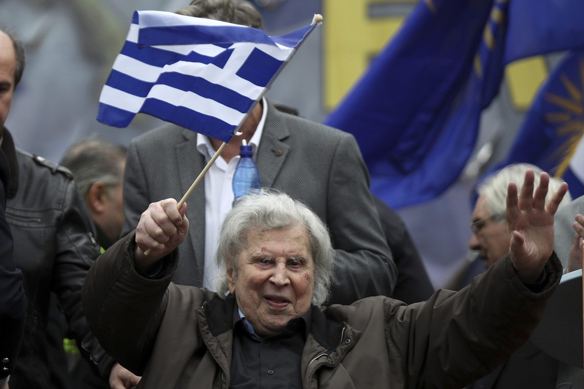 FILE - In this Sunday, Feb. 4, 2018 file photo, famous Greek composer Mikis Theodorakis waves a Greek flag after his speech at a rally in Athens, Greece. Mikis Theodorakis, the beloved Greek composer whose rousing music and life of political defiance won acclaim abroad and inspired millions at home, died on Thursday, Sept. 2, 2021. He was 96. (AP Photo/Petros Giannakouris, File) FILE - In this Sunday, Feb. 4, 2018 file photo, famous Greek composer Mikis Theodorakis waves a Greek flag after his speech at a rally in Athens, Greece. Mikis Theodorakis, the beloved Greek composer whose rousing music and life of political defiance won acclaim abroad and inspired millions at home, died on Thursday, Sept. 2, 2021. He was 96. (AP Photo/Petros Giannakouris, File)