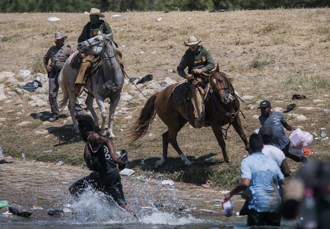 U.S. Customs and Border Protection mounted officers attempt to contain migrants as they cross the Rio Grande from Ciudad Acuña, Mexico, into Del Rio, Texas, Sunday, Sept. 19, 2021. (AP Photo/Felix Marquez) U.S. Customs and Border Protection mounted officers attempt to contain migrants as they cross the Rio Grande from Ciudad Acuña, Mexico, into Del Rio, Texas, Sunday, Sept. 19, 2021. (AP Photo/Felix Marquez)
