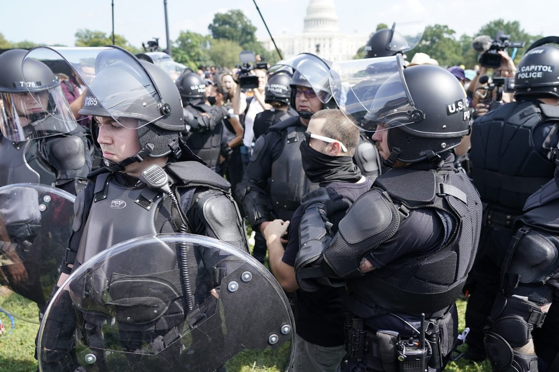 Police circle a man, center with glasses, during a rally near the U.S. Capitol in Washington, Saturday, Sept. 18, 2021. The rally was planned by allies of former President Donald Trump and aimed at supporting the so-called "political prisoners" of the Jan. 6 insurrection at the U.S. Capitol. (AP Photo/Gemunu Amarasinghe) Police circle a man, center with glasses, during a rally near the U.S. Capitol in Washington, Saturday, Sept. 18, 2021. The rally was planned by allies of former President Donald Trump and aimed at supporting the so-called "political prisoners" of the Jan. 6 insurrection at the U.S. Capitol. (AP Photo/Gemunu Amarasinghe)