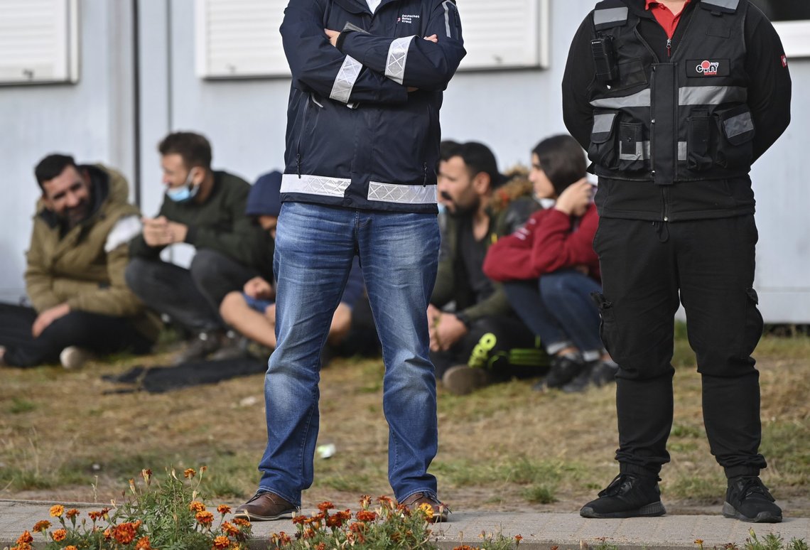 Tysk politi holder vakt foran en gruppe migranter utenfor et mottakssenter i Eisenhüttenstadt i delstaten Brandenburg. Foto: Patrick Pleul / AP / NTB Tysk politi holder vakt foran en gruppe migranter utenfor et mottakssenter i Eisenhüttenstadt i delstaten Brandenburg. Foto: Patrick Pleul / AP / NTB