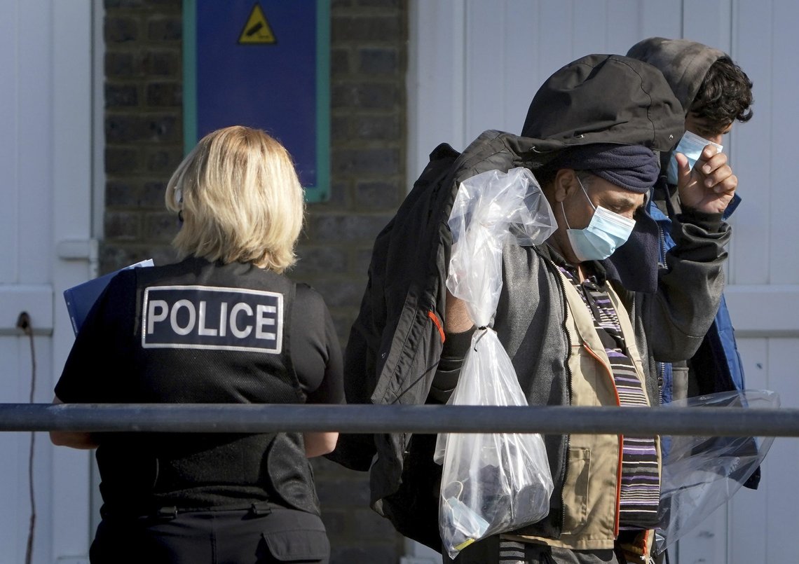 En gruppe migranter ivaretas av politi ved ankomst til Dover i England søndag. Foto: Gareth Fuller / PA via AP / NTB En gruppe migranter ivaretas av politi ved ankomst til Dover i England søndag. Foto: Gareth Fuller / PA via AP / NTB